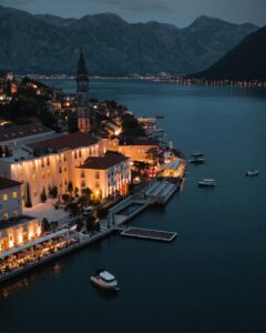 Aerial view of illuminated coastal town by Kotor Bay, Montenegro at dusk.