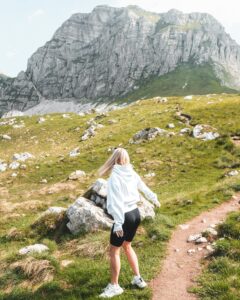 Woman hiking through Pošćenski Kraj's stunning mountain terrain in Montenegro, surrounded by natural beauty.