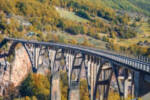 Breathtaking autumn view of the Durdevica Tara Bridge spanning across Tara Canyon in Montenegro.