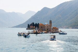 Scenic view of boats heading towards Our Lady of the Rocks island in Montenegro's Bay of Kotor.